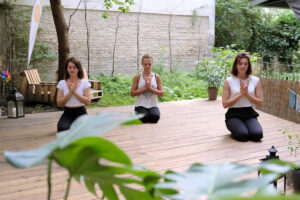 Foto 3 Personen praktizieren Yoga im Garten