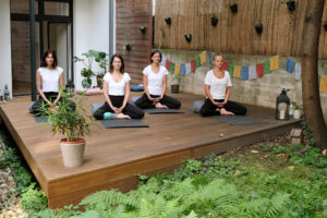 Foto 3 Personen praktizieren Yoga im Garten