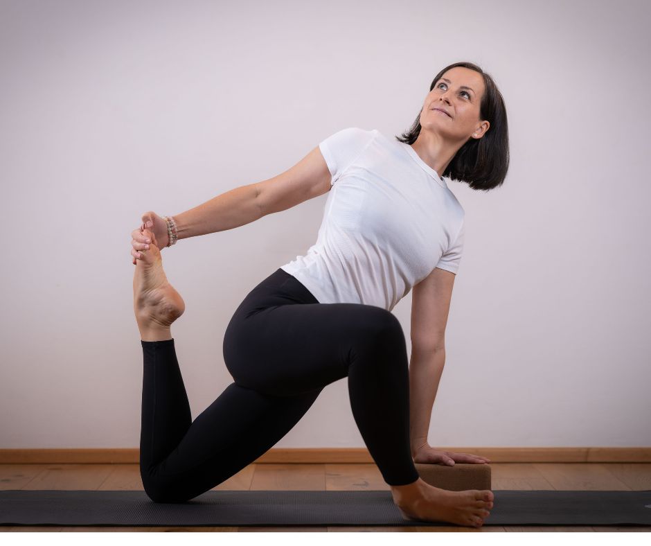 Klaudia in der Pose des twisted Lizzard auf ihrer Yogamatte