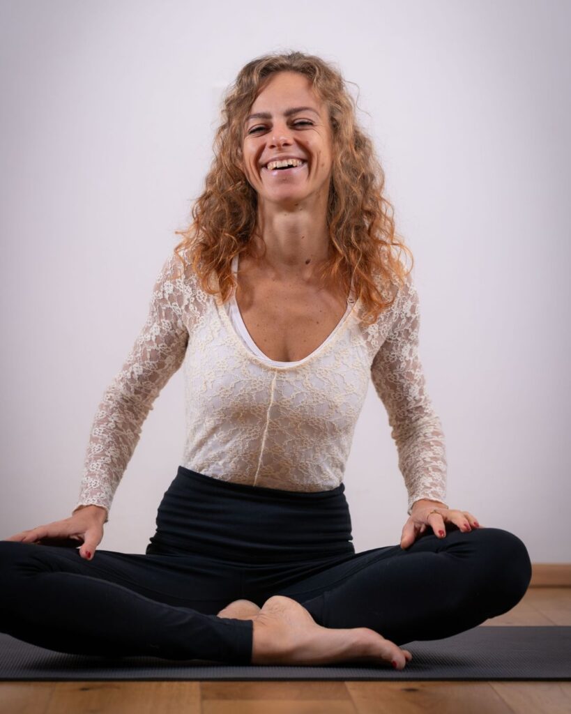 Magdalena Porträt 2025 Magdalena sitzt auf ihrer Yogamatte und lacht herzlich